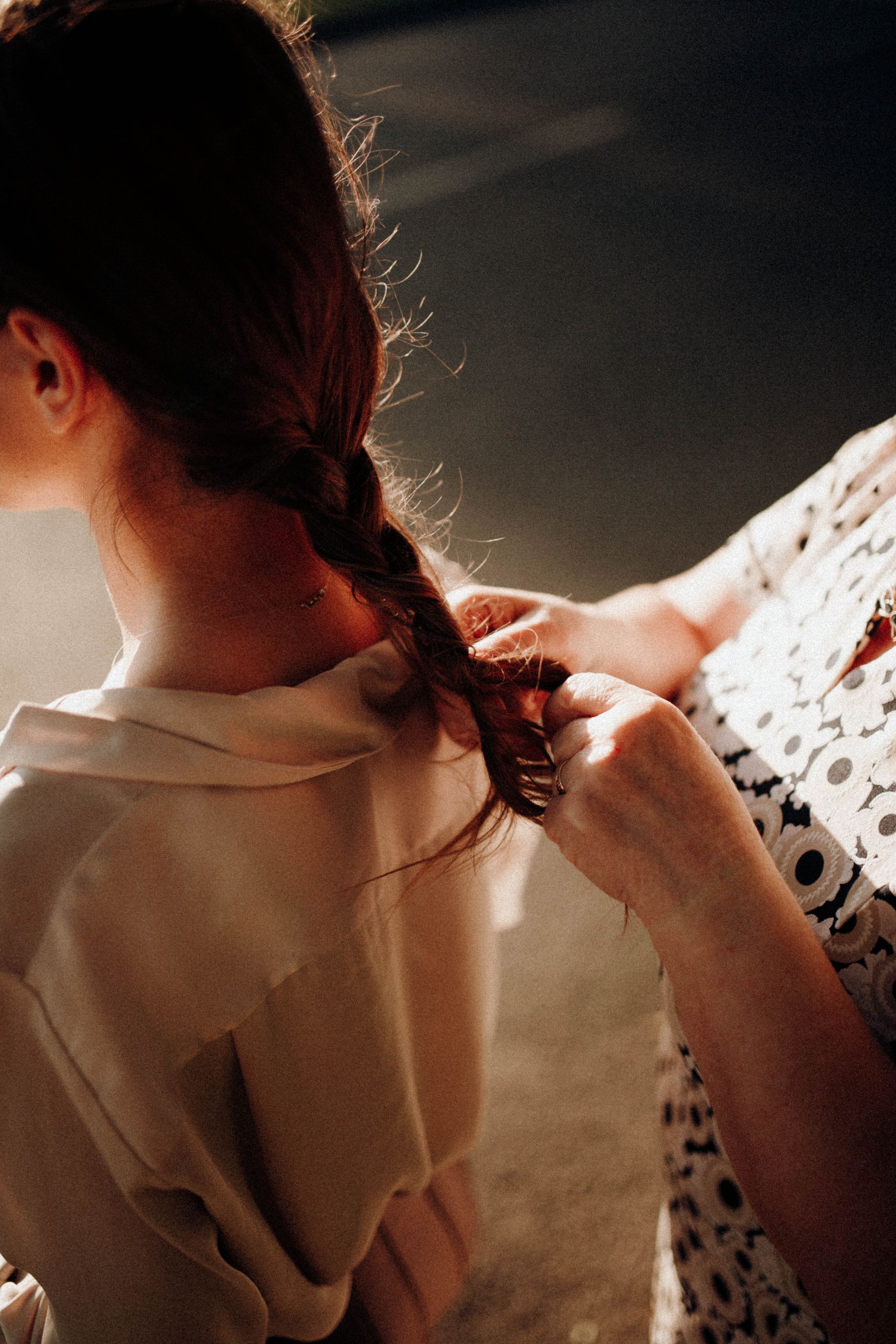 Stylist braiding a client's long hair